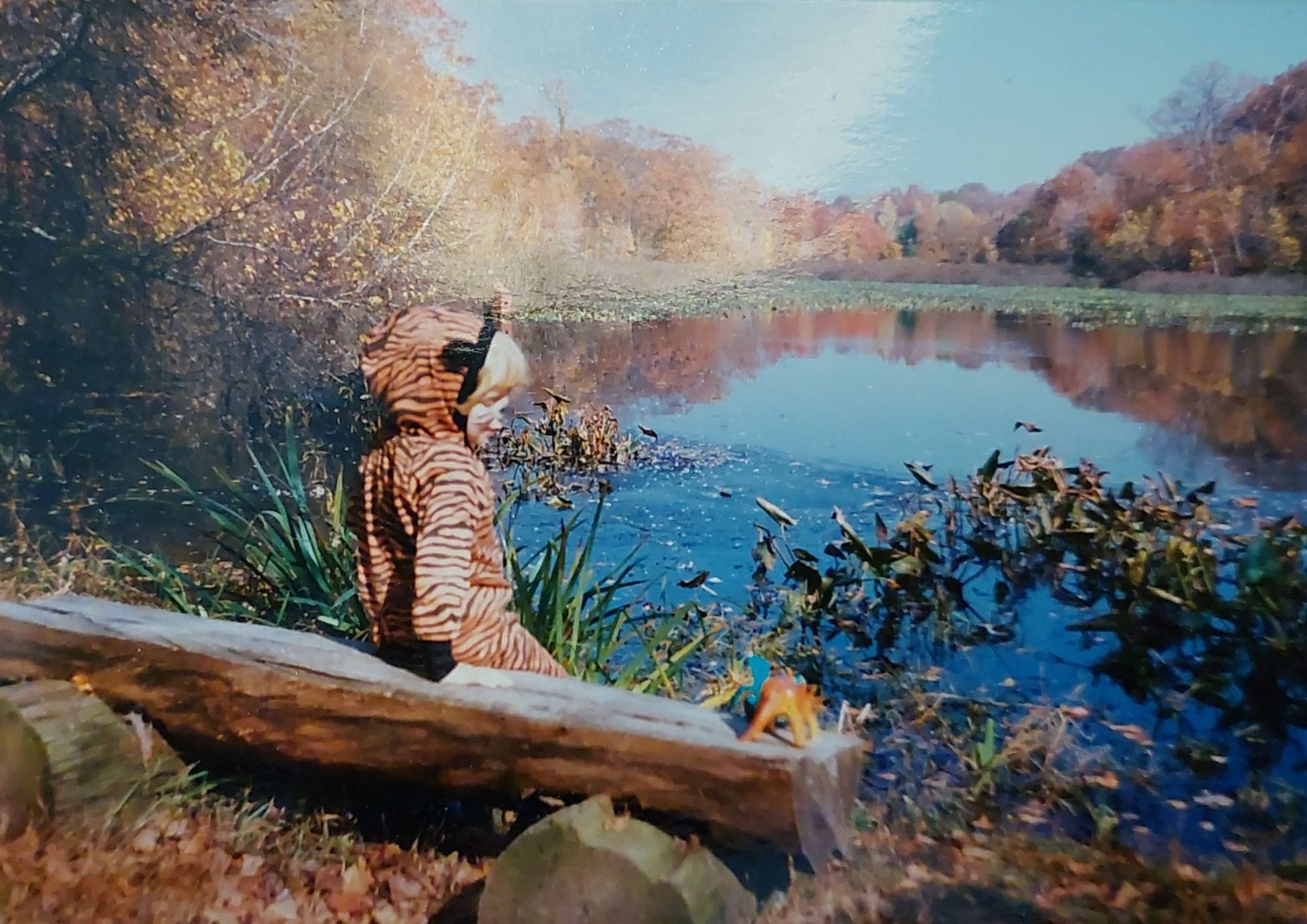 Foto von Florian als Kind am Seeufer sitzend.