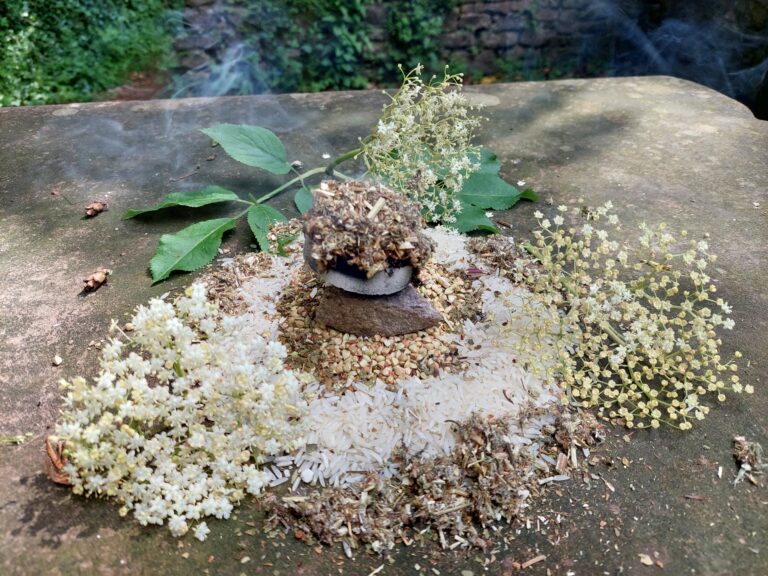 Bild einer Opfergabe, mit Räucherkohle und Holunderblüten